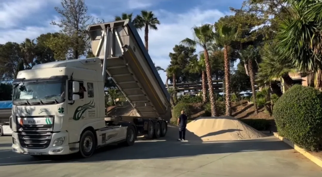 Camión de Transportes JJ García entregando material en una finca con jardín