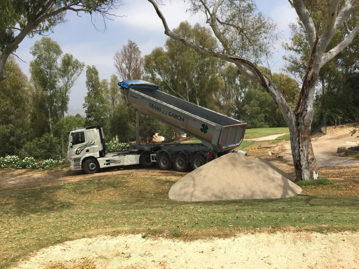 Camión de Transportes JJ García descargando árido en un campo de golf